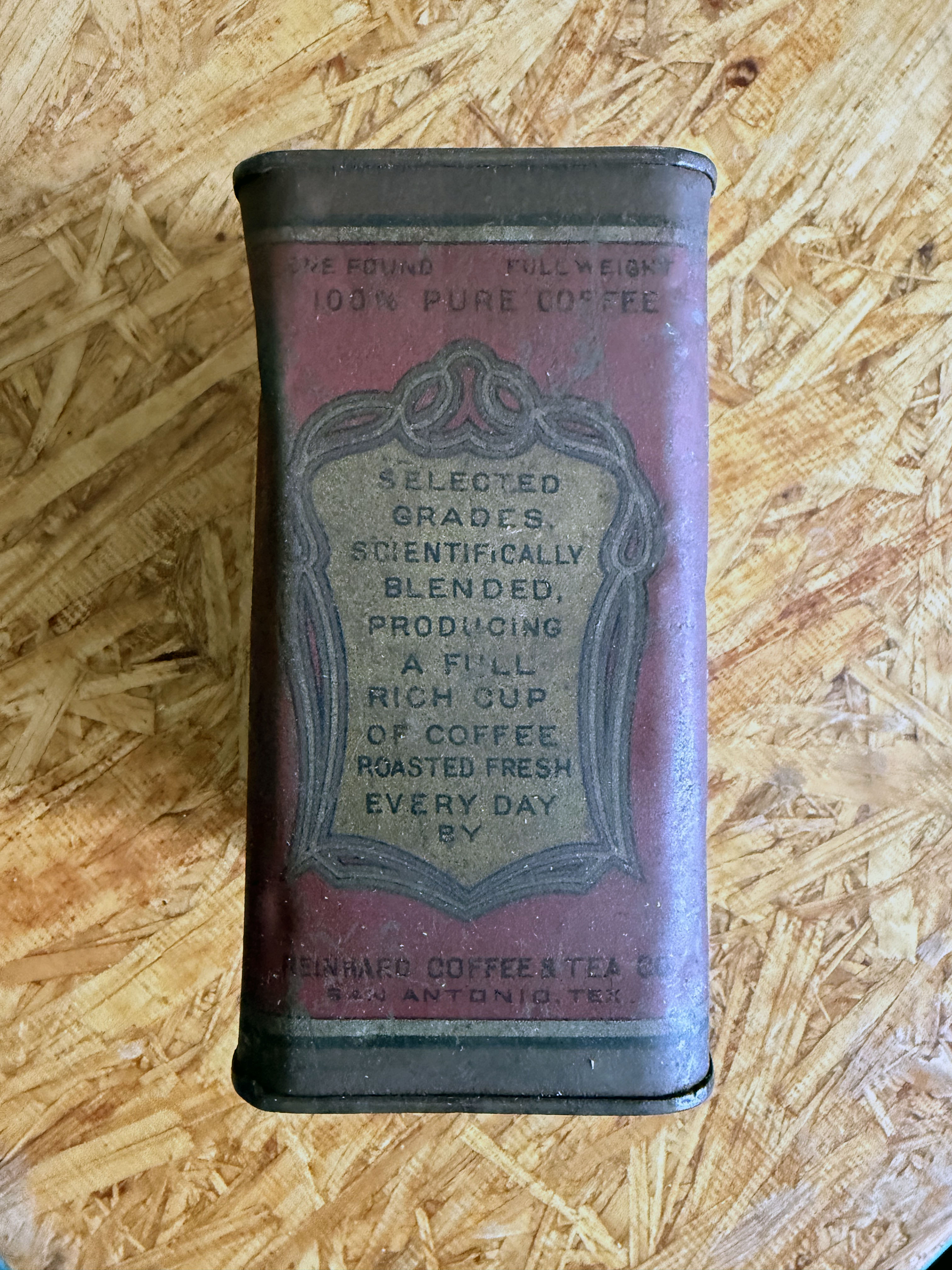 Opposite face: dark bands framing a gold shield with promotional copy — ONE POUND FULL WEIGHT, 100% PURE COFFEE, and stacked lines about selected grades, blending, and fresh daily roasting — closing again with REINHARD COFFEE & TEA CO., SAN ANTONIO, TEX.
