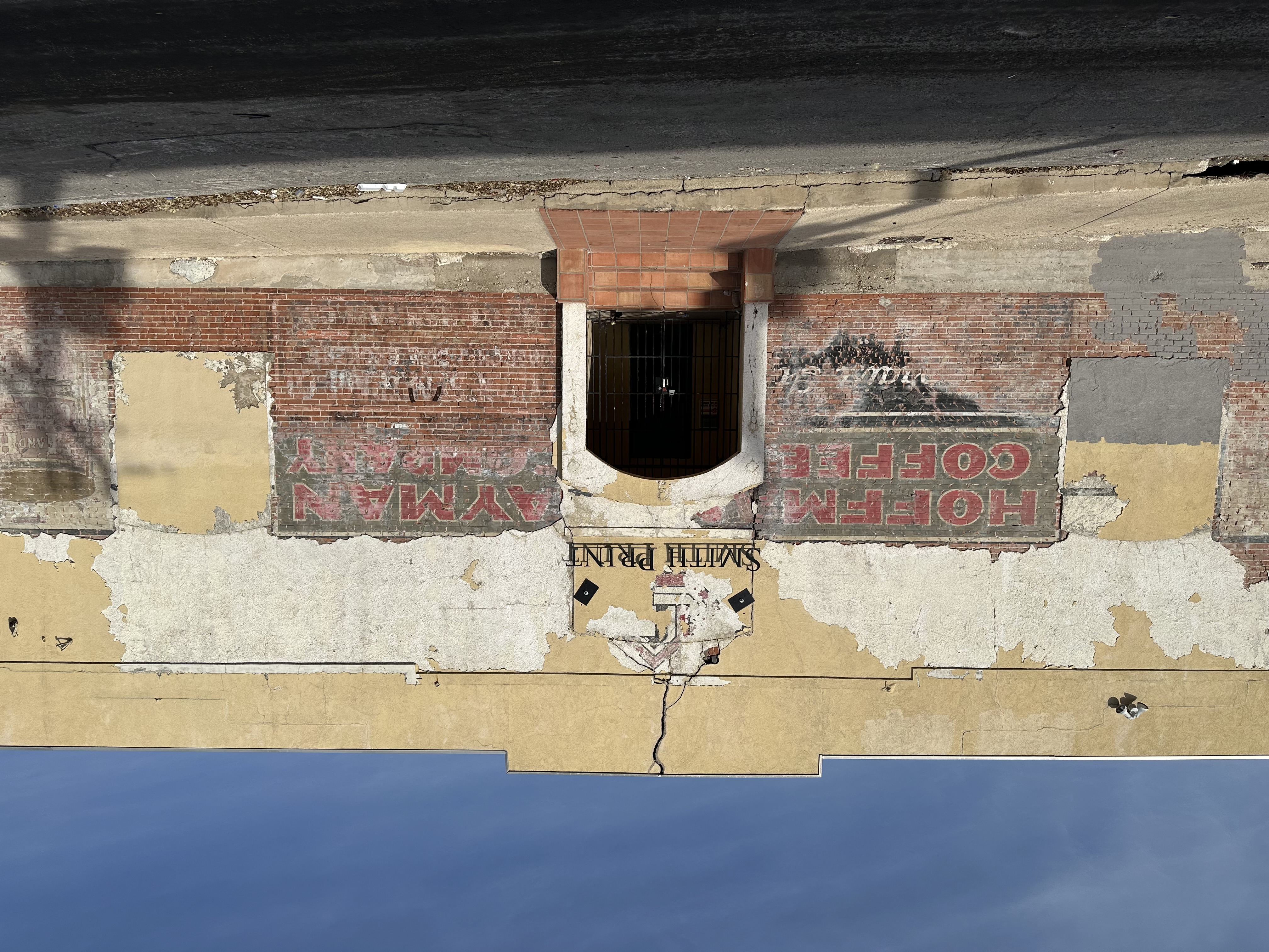 Front elevation — Smith Print sign over the arch; Hoffman Coffee (left) and Hayman Company (right) ghost lettering on brick