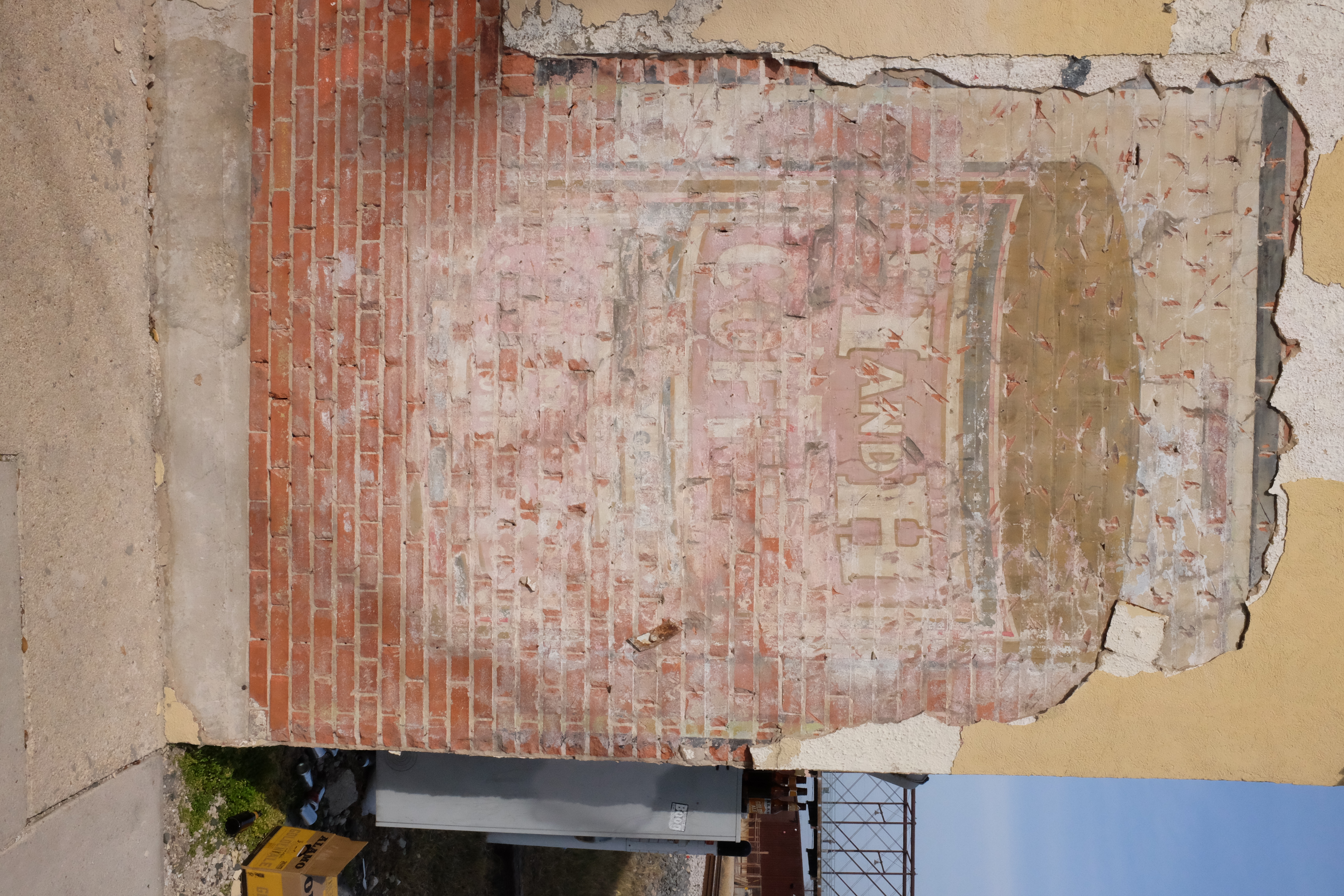 Large painted tin graphic — H AND H COFFEE — railroad bridge in the distance