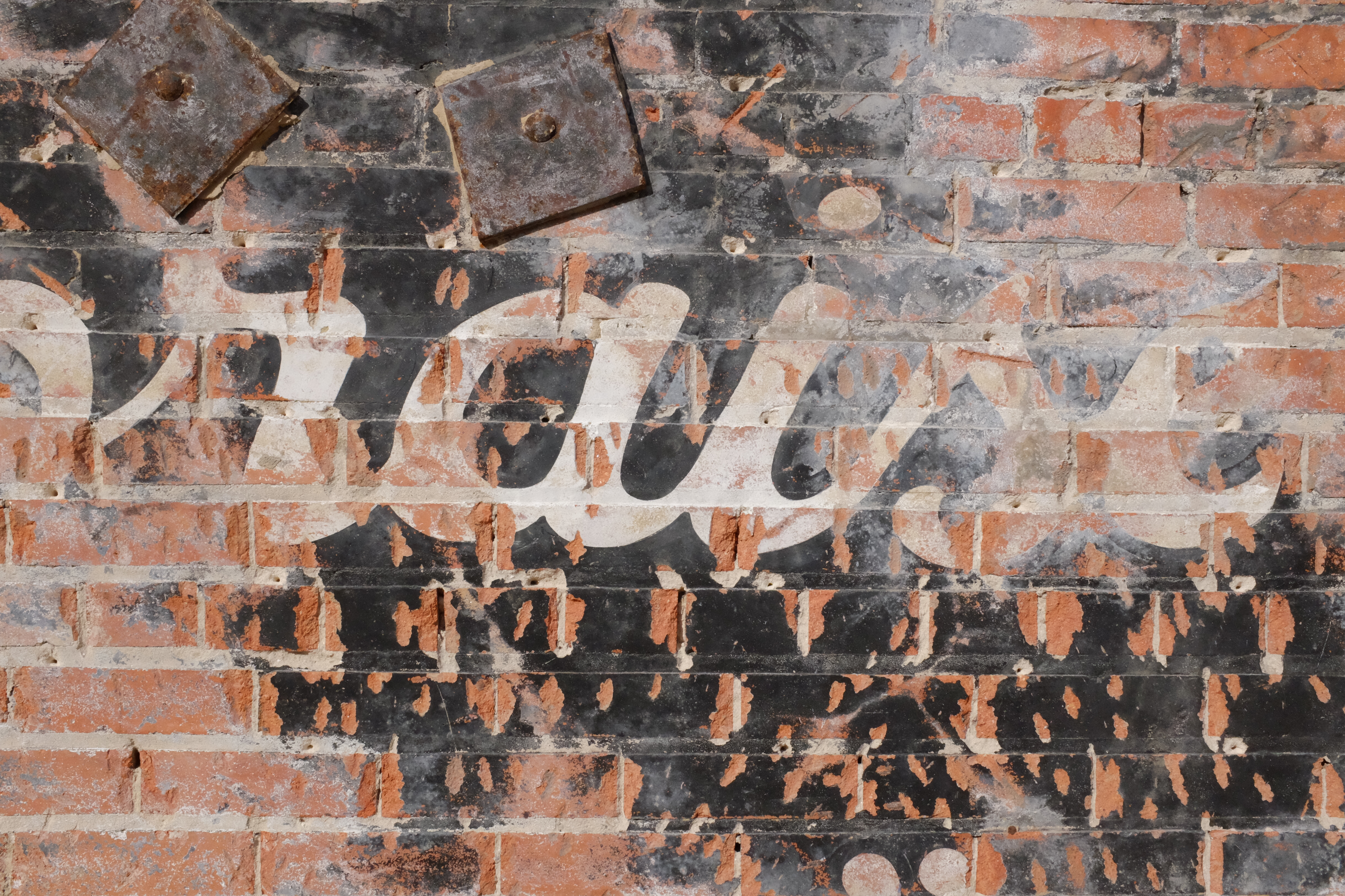 White script on black panel; structural tie plates