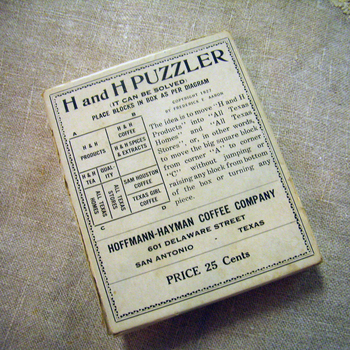 H and H PUZZLER cardboard box lid (copyright 1927, Frederick E. Aaron) — Hoffmann-Hayman promotional sliding-block puzzle; printed diagram labels H and H Products, H and H Coffee, H and H Spices and Extracts, H and H Tea, Quality, All Texas Homes, All Texas Stores, Sam Houston Coffee, Texas Girl Coffee; footer HOFFMANN-HAYMAN COFFEE COMPANY, 601 DELAWARE STREET, SAN ANTONIO - TEXAS, PRICE 25 Cents — project photograph 2 May 2015 (same 1927 premium form as the Hoffmann-Hayman Puzzler collection write-up)
