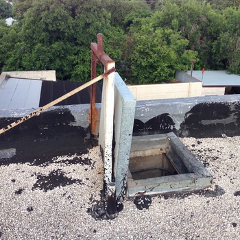 **8 June 2015** (**Apple iPhone 5**) — **ballasted flat roof** at Hoffmann-Hayman: open **roof hatch** with cover propped, rusted frame, pole and parapet; **white gravel** over black bitumen, treetops beyond — **roof access** documentation paired with other **parapet** frames.