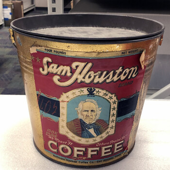 Color photograph **15 October 2019** — **Sam Houston Brand Coffee** **four-pound** pail, gold body where bare, full paper label: cream **'Sam Houston'** script, octagonal **portrait** of Sam Houston, **'FOUR POUNDS'** / **'NET WEIGHT'**, **'100% PURE'**, **'We Roast It'** / **'Others Praise It'** flanking **'COFFEE'**, footer **'Hoffmann-Hayman Coffee Co. San Antonio, Texas'**; handwritten **'1.05'** on label; label tear and wear, wire handle — **not in the project’s museum collection**