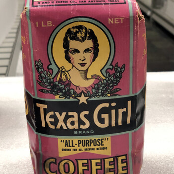 Color photograph **15 October 2019** — upright **one-pound** **Texas Girl** paper **bag**, pink, black, and yellow, **'1 LB. NET'**, **'H AND H COFFEE CO., SAN ANTONIO, TEXAS'**, circular portrait in yellow scalloped frame, **'Texas Girl'** / **'BRAND'** on black band, **'ALL-PURPOSE' GROUND FOR ALL BREWING METHODS'**, **'COFFEE'** and **'HIGH GRADE - FRESH ROASTED'**; top flap **FREE COUPON**; edge wear, white foam, shelving behind — **not in the project’s museum collection**