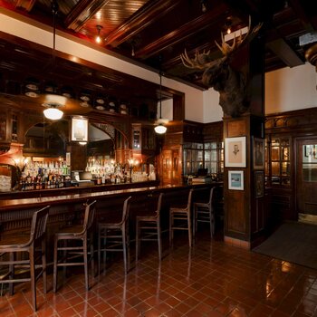 Modern interior photograph of the Menger Hotel bar, San Antonio, showing the historic dark-wood bar, columns, mounted taxidermy, and period fixtures (January 2026)