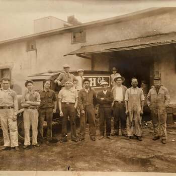 Crew posed beside H and H Coffee delivery trucks (location and date unknown)