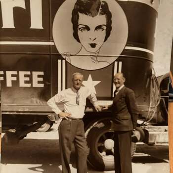 Two men posed beside a Texas Girl Coffee delivery truck