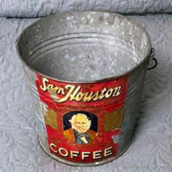 Open-top galvanized zinc Sam Houston Coffee pail with wire bail handle — worn red paper label wrapped around the body showing cream 'Sam Houston' script, an oval portrait of Sam Houston, and 'COFFEE' in block letters — from the Mac Johanson collection